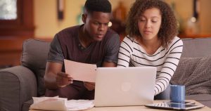 couple pays their bills on their laptop